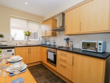 A kitchen with wooden cabinets black countertops and blue appliances at Valiant House in Scarborough