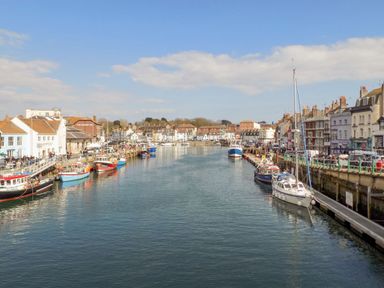 A harbor with boats docked along waterfront buildings at Fenders in Brewers Quay Harbour