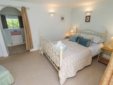 A bedroom with a double bed and bedside tables with lamps at The Coach House in Lowick near Holy Island