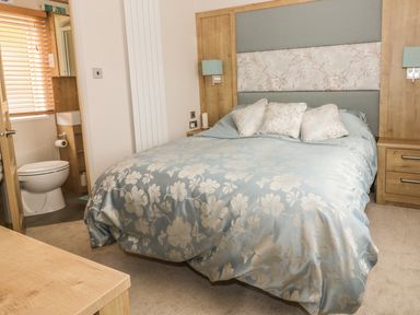 A bedroom with a bed and an ensuite bathroom at 27 Lake View in Cawston