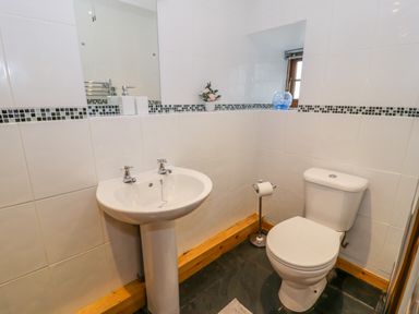 A bathroom with a pedestal sink toilet and small window at Yr Hen Stabal in Trawsfynydd