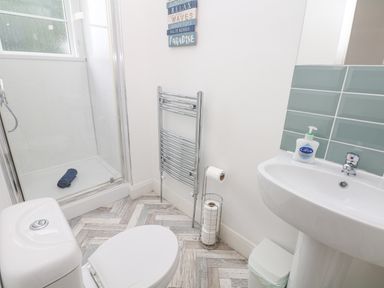 A bathroom with a toilet sink shower and towel rack at Babbacombe Hall in Babbacombe