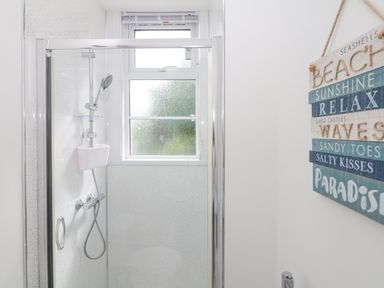 A shower area with a glass door and a window above at Babbacombe Hall in Babbacombe