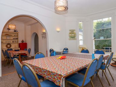 A dining room with a table and chairs at Babbacombe Hall in Babbacombe