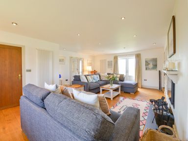 A living room with two grey sofas a coffee table a fireplace and wooden flooring at Duffield in St Ann's Chapel