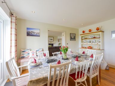 A dining room with a table set for eight and a cabinet with dishes at Duffield in St Ann's Chapel
