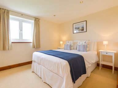 A bedroom with a bed and bedside tables with lamps at Duffield in St Ann's Chapel