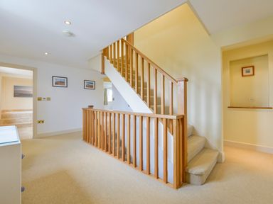A carpeted stairway with wooden railings and framed pictures on the wall at Duffield in St Ann's Chapel