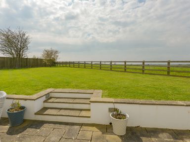 A garden with grass lawn stone steps and a wooden fence at Duffield in St Ann's Chapel