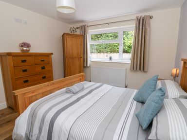 A bedroom with a bed and wooden furniture at New Peny in Llandrindod Wells