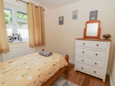 A bedroom with a bed and dresser at New Peny in Llandrindod Wells
