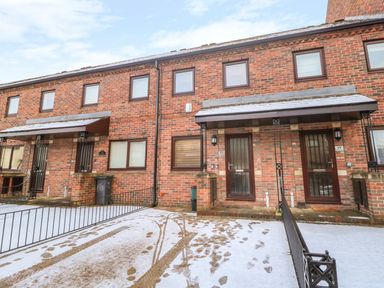 A row of brick terraced houses with front porches and snow on the ground at 17 Fewster Way York