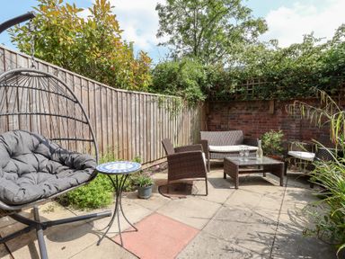 A garden with a hanging chair and seating area at 17 Fewster Way in York