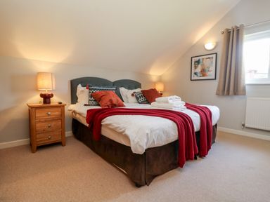 A bedroom with a double bed nightstands lamps and window at Lodge Sixty Six in St Columb Major