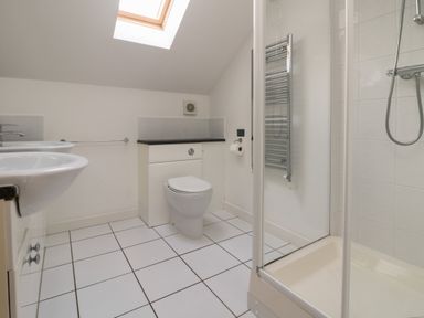 A bathroom with a sink a toilet a shower cubicle and a skylight at Lodge Sixty Six in St Columb Major