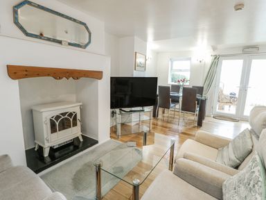 A living room with a fireplace and television at Preswylfa Apartment in Caernarfon