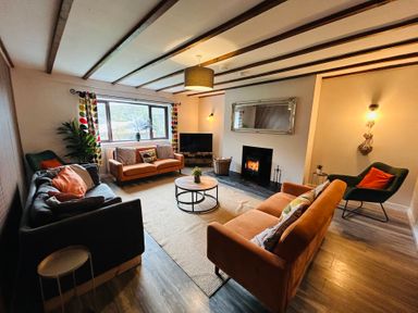 A living room with a fireplace and sofa arrangements at Stiniog Lodge in Blaenau Ffestiniog