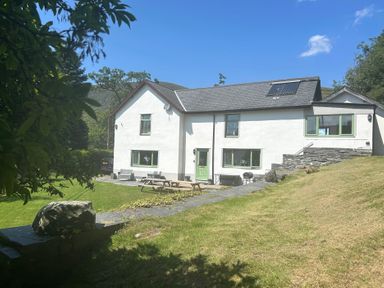 A house with a lawn and patio table at Stiniog Lodge in Blaenau Ffestiniog