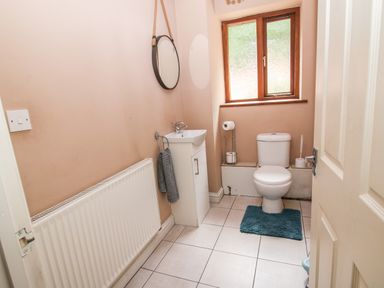 A bathroom with a toilet a sink a mirror a towel radiator and a window at Shatterford Lakes in Shatterford