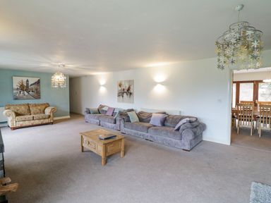 A living room with two sofas a wooden coffee table and a chandelier at Shatterford Lakes in Shatterford