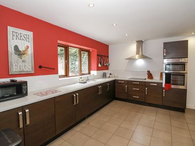 A kitchen with dark wood cabinets stainless steel appliances and a window over the sink at Shatterford Lakes in Shatterford