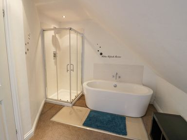 A bathroom with a shower enclosure a bathtub and a blue bath mat at Shatterford Lakes in Shatterford
