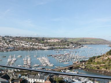 A view of a marina with many boats and houses on a hillside by the water at Moorings in Kingswear Devon