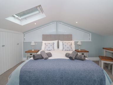 A bedroom with a bed featuring pillows and rolled towels under a skylight window at Moorings in Kingswear Devon