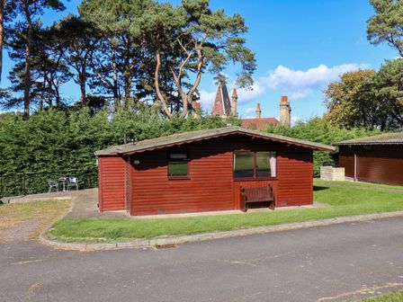 A log cabin with windows and outdoor seating at Orchid Lodge in Saltburn-by-the-Sea