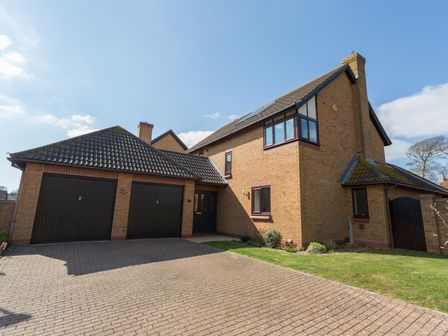 A detached house with a double garage and driveway at Connaught Gardens in Weymouth