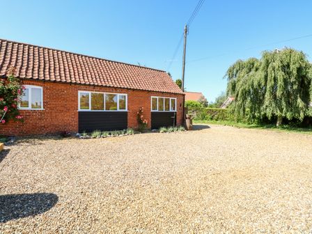 A gravel driveway in front of a brick house with tiled roof and windows near a tree at The Duck House in Thompson near Watton
