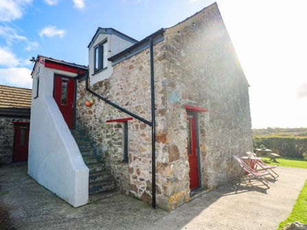An exterior view of a stone building with stairs and doors at Hayloft near Narberth