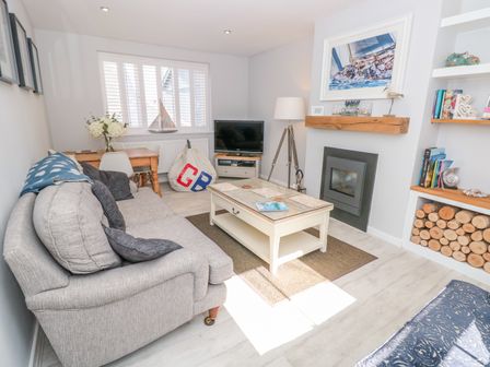 A living room with a sofa coffee table fireplace and TV at Upper Deck in Dartmouth