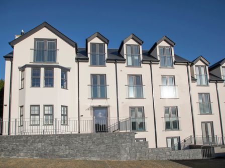 Exterior view of a multi-story building with multiple windows and balconies at Sea Breeze in Benllech