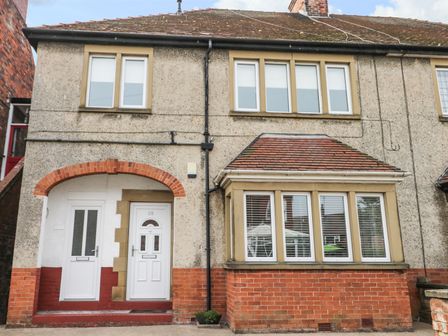 A front view of a two storey house with white doors and multiple windows at Angel by the Sea in Bridlington