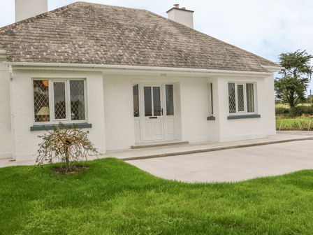 Front exterior of a white house with a tiled roof a door and windows at Dirreen House in Athea near Listowel County Kerry