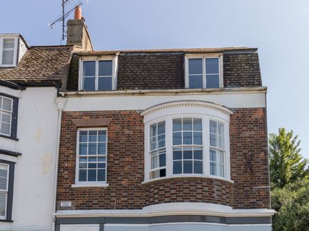 A brick and white building facade with multiple windows on Trinity Road