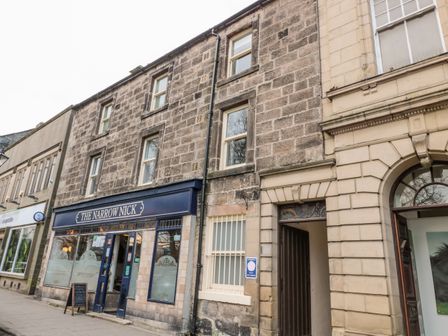 Street view of a building with a pub named The Narrow Nick and adjacent shops in Rothbury