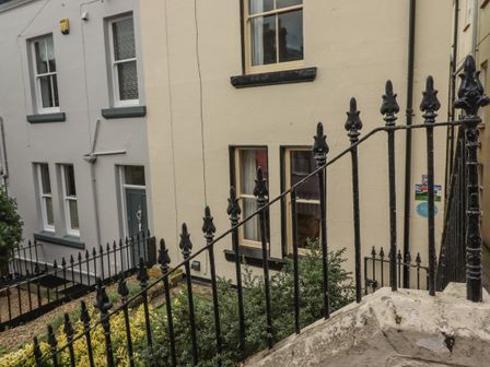 The exterior of residential buildings with windows doors and black iron railings at West End House in Whitby