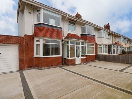 A row of houses with brick and white exterior and concrete driveways at Belvedere House in Bridlington