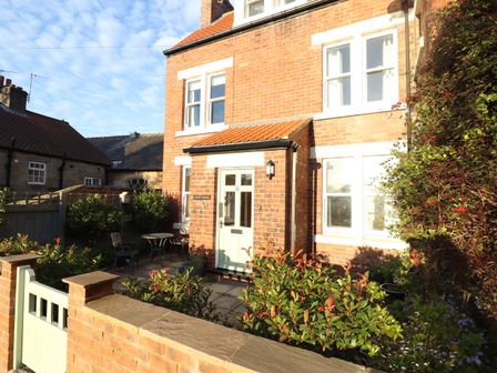 A brick house with a small front garden and patio furniture at Arden House in Whitby