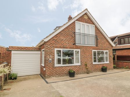 A brick house with a garage and paved driveway at Abbey View in Whitby