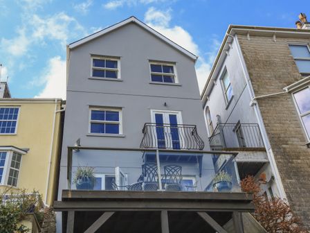 The back exterior of a multi-story house with balconies and patio furniture at 29 Above Town in Dartmouth