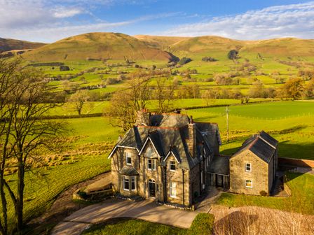 A country house with driveways surrounded by fields and hills at Oakdene Country House in Sedbergh