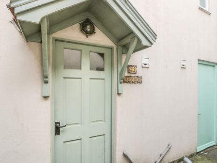 An exterior entrance door with a green porch and a sign reading Fawcet House at Fawcet House in Whitby