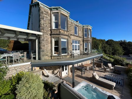 An outdoor area with a terrace and hot tub at Victoria Mount in Grange-Over-Sands