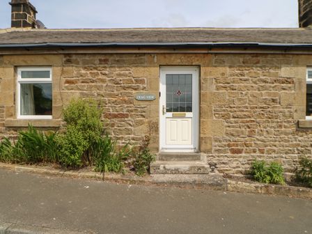 Stone house exterior with white door and windows and plants along the front at Crag View in West Woodburn