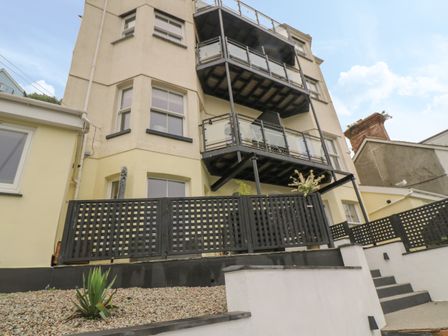 Exterior view of a multi-story building with balconies and black railing at 1 River View in Looe