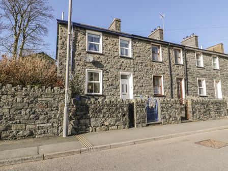 Stone terraced houses with front walls and gates along a street at Manod View in Blaenau Ffestiniog