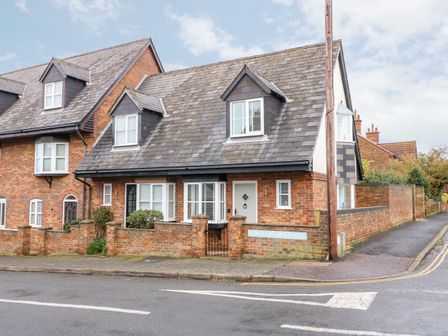 A brick house with dormer windows and a small front garden behind a brick wall on Lower Lincoln Street in Hunstanton